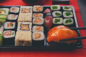 Eating sushi and rolls in japanese restaurant