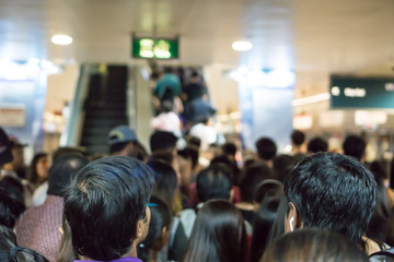 Crowded Asian people queue for escalator to exit from public subway during rush hour