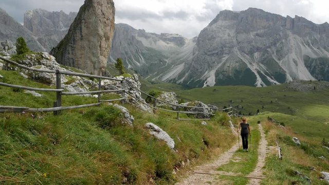 Women makes a hike and goes up the path in a mountainous area
