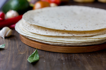 Mexican flatbread tortilla on wooden background.