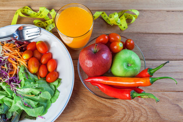 Fresh healthy salad with different fruits and vegetables on wooden background