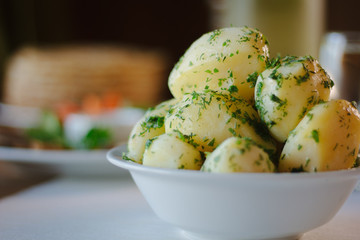 Young potatioes boiled with the herbs at restaurant table.