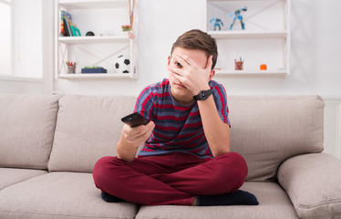 Boy watching horror movie on couch at home