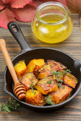Baked slices of pumpkin with thyme and honey. Vegetarian food. Halloween. Thanksgiving. A rustic style. Selective focus