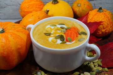 Spicy pumpkin soup in a white bowl, selective focus