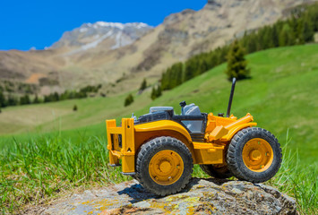 toy tractor on rock in mountain