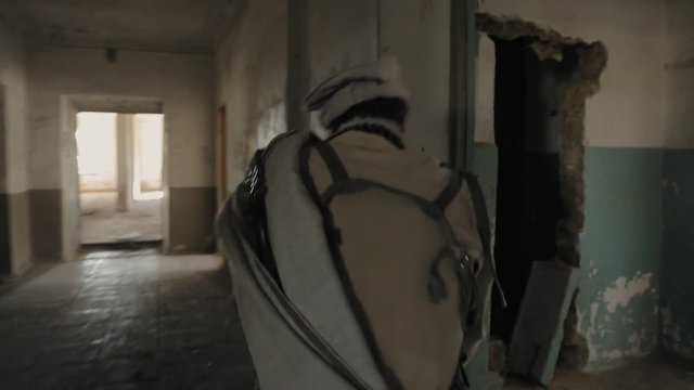 Two armed Mujahideen walk along the corridors of the abandoned building and hunt down the enemy