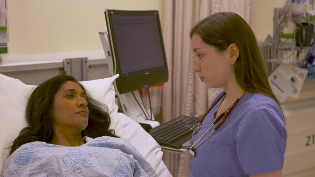 Close up emotional moment as a nurse delivers bad news to a patient in the hospital.