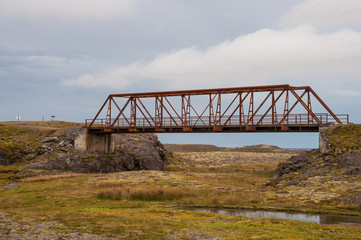 old Bridge over Heinabergsfljot river in Iceland. due to glacier melting the river has changed route so the bridge does not have any function today