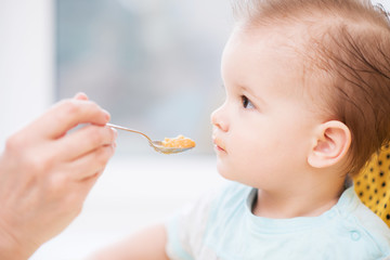 grandmother gives baby food from a spoon