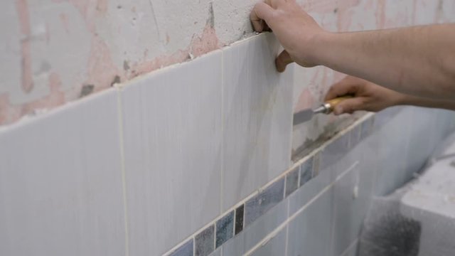 Removal of old ceramic tiles with a chisel and a hammer
