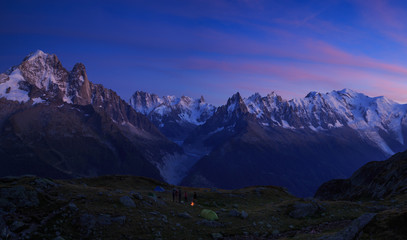 Campfire at a campsite in the mountains near Chamonix, France, during a colorful sunset.