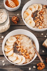 healthy breakfast bowl. oatmeal with banana, walnuts, chia seeds and honey