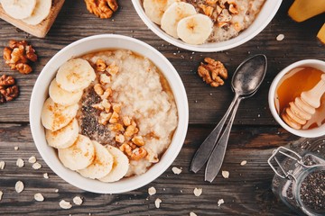healthy breakfast bowl. oatmeal with banana, walnuts, chia seeds and honey