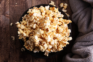 Salt popcorn or sweet popcorn in bowl on the wooden table