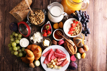 Obraz na płótnie Canvas Breakfast served with coffee, orange juice, croissants, cereals and fruits. Balanced diet.