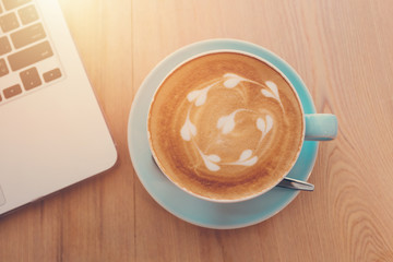Cup of coffe on workplace desk, coffee shop.