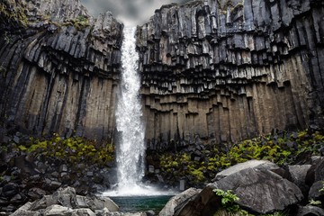 Svartifoss (Black Falls) waterfall flowing over tall black basalt columns, Skaftafell, Vatnajokull National Park, Iceland