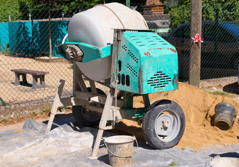 small blue concrete mixer on a construction site
