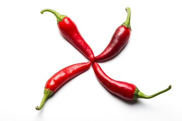Four red chili peppers in the form of a cross on a white background.