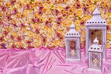 Background of pink and yellow roses and burning lanterns
