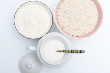 Fototapeta na wymiar vista cenital de juego de tazas con harina, arroz y azucar sobre fondo blanco