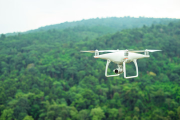 Fototapeta na wymiar White drone flying over the green mountain