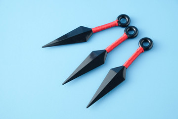 To throw ninja weapons isolated on blue paper background