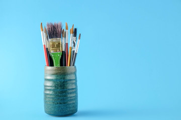 Row of artist paint brushes close up on blue  background