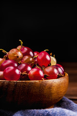 Fresh gooseberries in wooden bowl