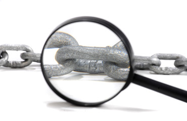 Kette mit Lupe - Symbolfoto für Gefangenschaft