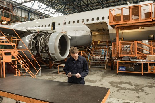 Male aircraft maintenance engineer using digital tablet