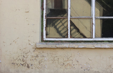 Shabby wall  and old window with reflection in it