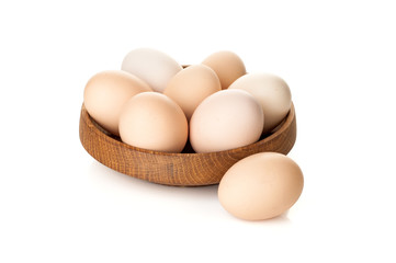 chicken eggs in a wooden plate isolated on white background