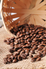 Coffee beans spilled from the basket on a burlap