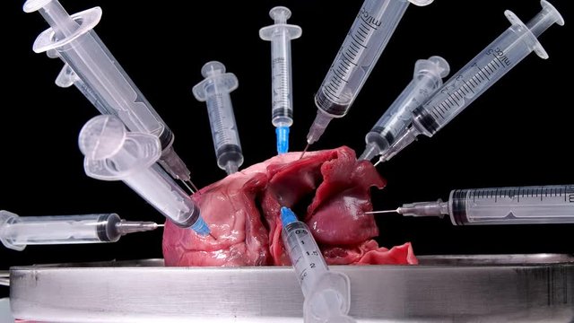 heart pricked with syringe on black background