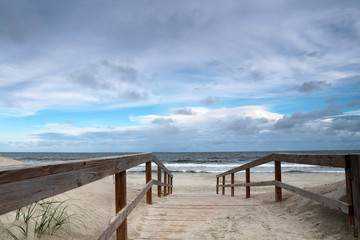 Fototapeta na wymiar Way to the beach. Marine landscape with wooden boardwalk leads to the atlantic ocean beach. Pawleys Island, Myrtle Beach area, South Carolina USA.