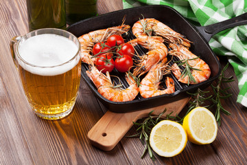 Grilled shrimps on frying pan and beer