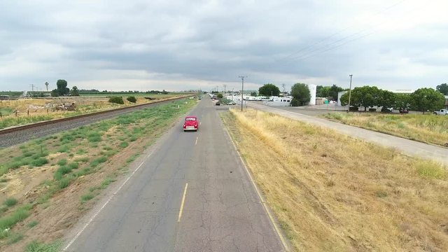 Red Classic Truck Driving on Empty Road in Country