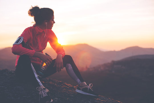 Athletic woman resting after a hard training in the mountains at sunset. Sport tight clothes. © Alex from the Rock
