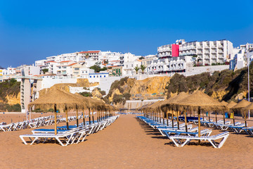 Rows of beach parasols with buildings