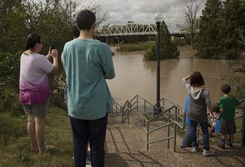 Family looking down steps taking photos of flooded town