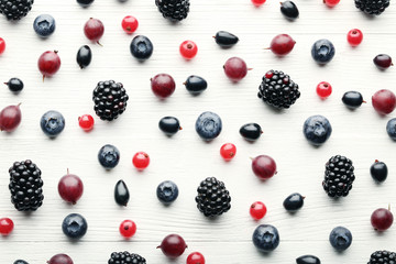 Ripe and sweet berries on white wooden table