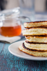 white plate full of pancakes on a wooden background