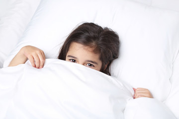 Beautiful little girl sleeping in white bed