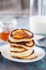 white plate full of pancakes on a wooden background