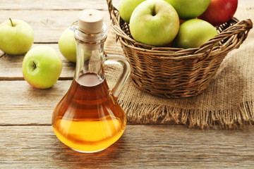 Apple vinegar in glass bottle on grey wooden table
