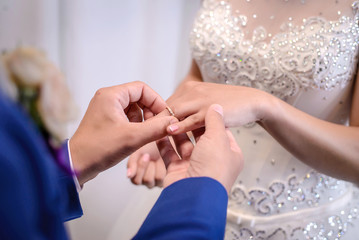 The groom places the wedding ring on the bride's finger