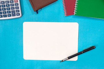 notebook, calculator and pen isolated on blue background