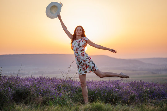 Smiling woman posing on one leg on lavender sunset